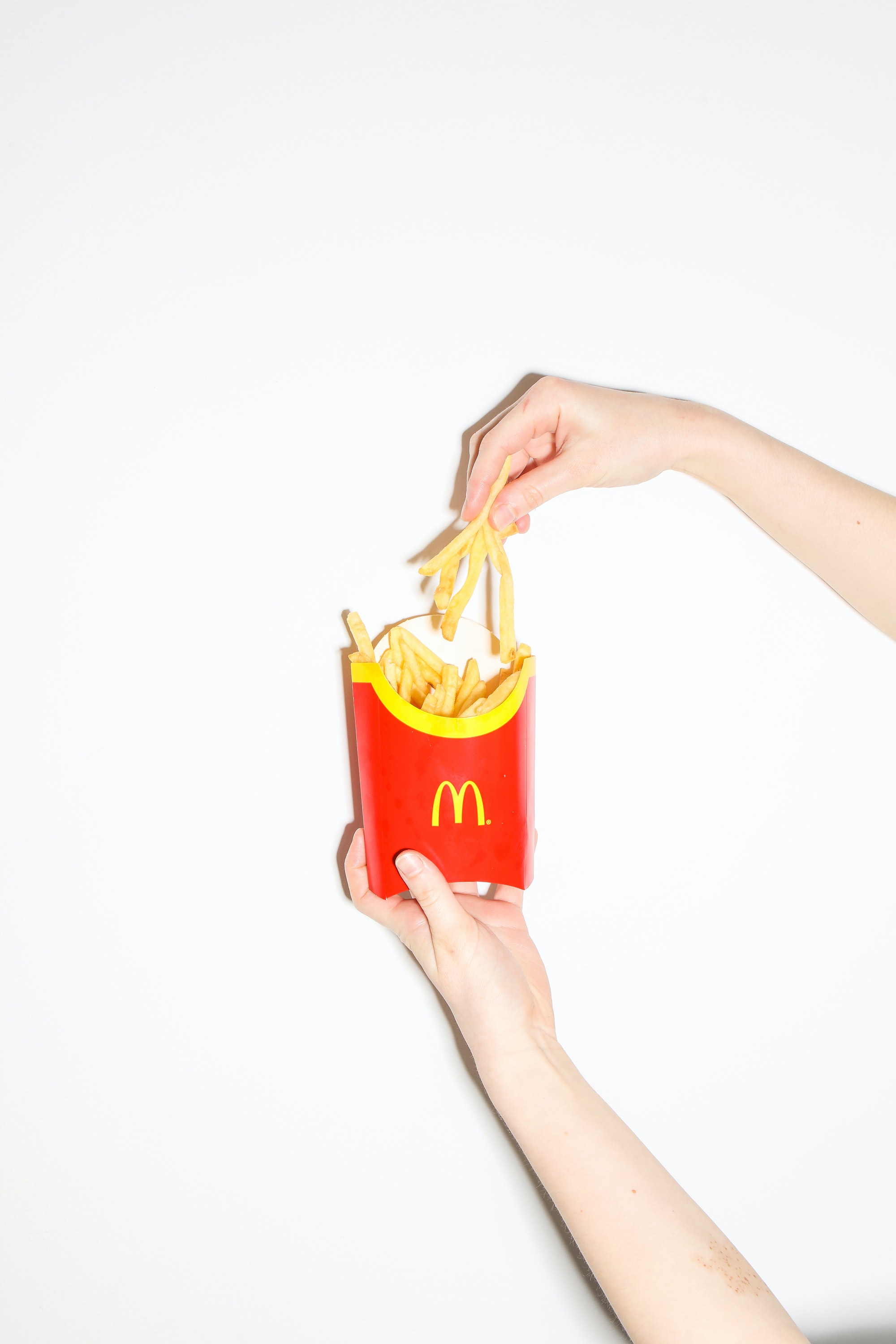 mcdonalds fry box with hand picking fries out